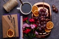 Aesthetic breakfast with grapes on the golden tray, cup of coffee, dry oranges, books and flowers close up