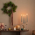 Aesthetic composition of christmas living room interior with wooden console, christmas gifts, candle with candlestick, christmas Royalty Free Stock Photo