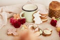 Aesthetic cozy Easter table with milk mug with glazed cookies, Cake and flowers. Springtime holiday floral background.