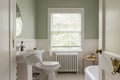 Aesthetic creme bathroom with a white toilet, sink and a large window