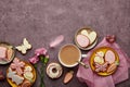 Aesthetic Easter background complete coffee cup, decorated cookies, feathers and aster flowers flat lay with copy space