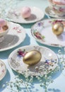Aesthetic Easter composition made of vintage plates and golden eggs