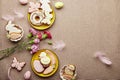 Aesthetic Easter flat lay with copy space. Decorated Easter cookies, pink flowers with feathers. Spring background