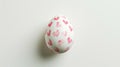 Aesthetic Easter white egg painted with red hearts. White background. Copy space. Generative AI Royalty Free Stock Photo