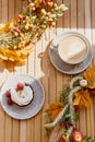 Aesthetic french berries cupcake and cup of cappuccino among autumn atmospheric decoration. Cozy breakfast outside with