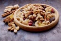Aesthetic wooden bowl with assorted nuts, raisins and cranberries from above on rustic background. Hazelnuts , walnuts Royalty Free Stock Photo