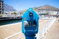 Aesthetically pleasing, blue, coin operated lookout scope. Standing outside of the Waterfront. Facing the harbor and mountain.