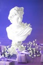 Aesthetics of Ancient Greece, bust with gift boxes of trendy lilac color in neon lighting. The concept of March 8 and