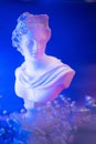 Aesthetics of Ancient Greece, bust with gift boxes of trendy lilac color in neon lighting. The concept of March 8 and