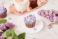 Aesthetics close up purple floral cupcakes using trend Dreamy Escapism. Desserts and flowers background