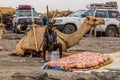 AFAR, ETHIOPIA - MARCH 25, 2019: Tourist vehicles, camel and a local boy in Dodom village under Erta Ale volcano in Afar