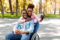 Affectionate black woman and her impaired boyfriend in wheelchair taking selfie together at autumn park Royalty Free Stock Photo
