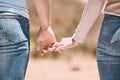 Affectionate couple holding hands showing love, caring and bonding outside together in nature. Loving boyfriend and