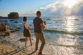 Happy loving couple meet sunrise and play at the beach in ocean shore. sun glare in the frame Royalty Free Stock Photo