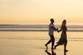 Affectionate couple walking on beach at sunset Royalty Free Stock Photo