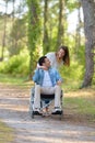 affectionate couple in wheelchair in forest