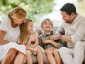 Affectionate family of four sitting on their sofa in the living room at home. A mother, father, son and daughter Royalty Free Stock Photo