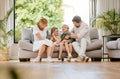Affectionate family of four sitting on their sofa in the living room at home. A mother, father, son and daughter Royalty Free Stock Photo