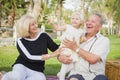 Affectionate Granddaughter and Grandparents Playing At The Park