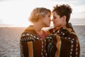 Affectionate lesbian couple wrapped in a beach blanket at dusk Royalty Free Stock Photo