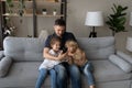 Affectionate loving father and small children using cellphone at home. Royalty Free Stock Photo