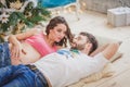 Affectionate man kissing his pregnant wife with baby letters on the belly lying on the sofa at home