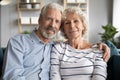 Affectionate mature retired married couple cuddling on comfortable sofa. Royalty Free Stock Photo