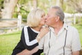 Affectionate Senior Couple Kissing At The Park