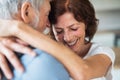 Affectionate senior couple in love standing indoors at home, hugging.