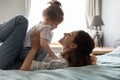 Affectionate small baby girl playing together on bed.