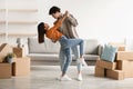 Affectionate young Asian couple dancing in their house among cardboard boxes on moving day, full length Royalty Free Stock Photo