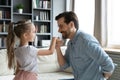 Affectionate young dad kissing hand of cute little kid daughter. Royalty Free Stock Photo