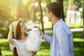 Affectionate young guy feeding cotton candy to his lovely girlfriend at park Royalty Free Stock Photo