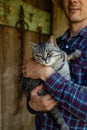 Affectionate young male farmer petting cat in barn. Royalty Free Stock Photo