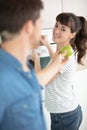affectionate young man offers girlfriend juicy green apple Royalty Free Stock Photo