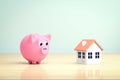 Affordable Accommodation Mortgage loan symbol - pink piggy bank, new home and pile gold coins