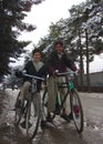 Boys smile riding bicycles in Afghanistan winter