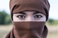 An Afghan woman in a hijab, close-up.