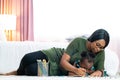 Afican american family together painting at home. Little daughter and her mother are drawing with colorful pencils Royalty Free Stock Photo