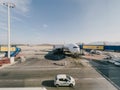 Afines, Greece - 20 august 2023: Plane with a telescopic gangway and airport services trucks stands on the runway Royalty Free Stock Photo