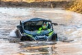 Smiling sportsman drives buggy deep in water at Mud Racing contest. ATV SSV motobike Royalty Free Stock Photo