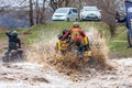 Sportsmen on BRP Can-Am quad bikes drive splashing in dirt and water at Mud Racing contest. ATV SSV motobike competitions are Royalty Free Stock Photo