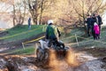 Sportsman on quad bike drives splashing in water at Mud Racing contest. ATV SSV motobike