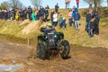 Sportsman on quad bike drives splashing in water at Mud Racing contest. ATV SSV motobike