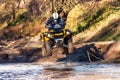 Sportsman on quad bike jumping in deep water at Mud Racing contest. ATV SSV motobike