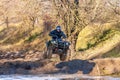 Sportsman on quad bike jumping into water at Mud Racing contest. ATV motobike competitions is Royalty Free Stock Photo