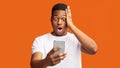 Afraid african guy looking at phone reading terrible news Royalty Free Stock Photo