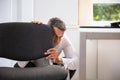 Afraid Businessman Peeking Behind Chair