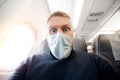 Afraid of fear flying on airplane and height tourist man in safe medical mask. Concept aerophobia or aviophobia