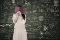 Afraid female student hide behind book in class